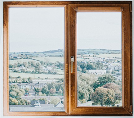 Window looking out over trees and rolling hills.
